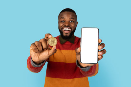 Online Trading. Excited Black Man Showing Golden Bitcoin Coin And Blank Smartphone
