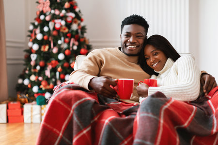 Happy Black Family Enjoying Christmas Movies Together in Cozy Living Roomの写真素材