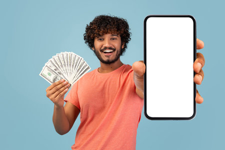 Young Eastern Man Holds Smartphone and Cash While Showing Excitement About Online Trading