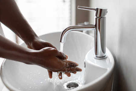 Closeup of Man Washing Hands in Modern Bathroom Sink With Flowing Waterの写真素材
