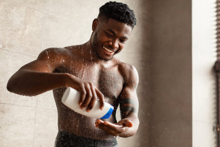 Happy Man Enjoying Body Wash in Modern Bathroom During Self-Care Routineの写真素材