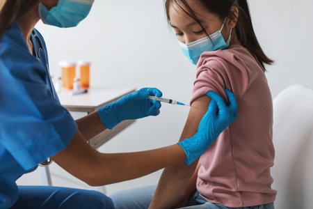 Japanese Preteen Girl Receives Coronavirus Vaccine in Modern Clinic Settingの写真素材