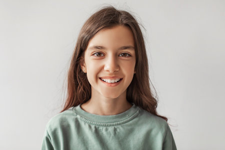 Happy Girl Smiling at the Camera in Casual Clothing With Gray Backgroundの写真素材