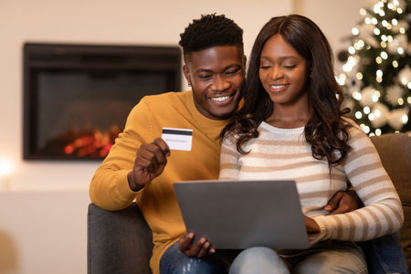 Couple Enjoying Online Shopping for Christmas Gifts on a Cozy Evening at Homeの写真素材