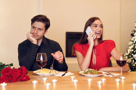Romantic Dinner Disrupted by a Phone Call During a Festive Evening at Homeの写真素材