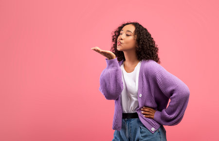 Young Black Woman Blows Air Kiss With Love Against Pink Background for Valentines Dayの写真素材