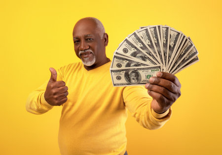 Happy Senior Man Celebrating Wealth With Cash and Thumbs up Gesture in Studio Setting