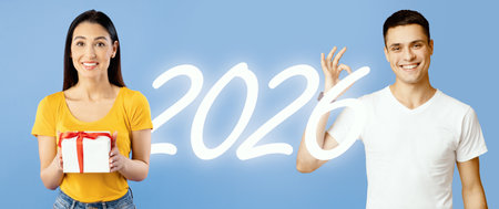 Confident Young Woman With Gift and Smiling Man Celebrating New Year Against Blue Backdropの写真素材