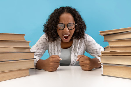 Student Expressing Frustration Over Studies While Surrounded by Books in Blue Studio