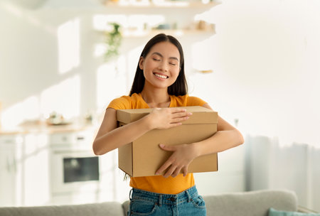 Excited Woman Joyfully Embracing Her Delivery at Home After Ordering Onlineの写真素材