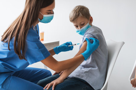 Preteen Boy Receives Covid-19 Vaccination in Modern Clinic Setting Indoorsの写真素材