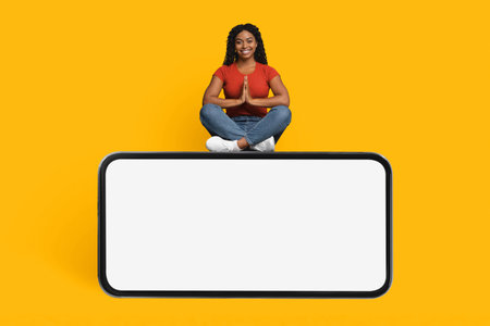 Creative Woman Sitting in a Yoga Pose on Top of a Rectangular Surface Against a Bright Backgroundの写真素材