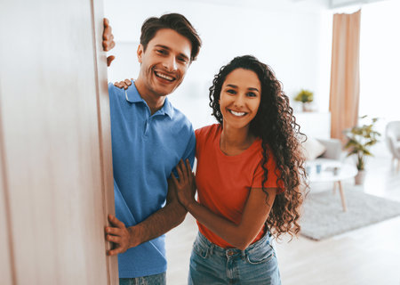 Couple Smiling as They Enter a Bright Living Room Together in the Afternoonの写真素材