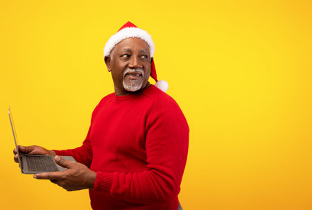 Senior Black Man Prepares for Holiday Shopping While Looking for Seasonal Dealsの写真素材