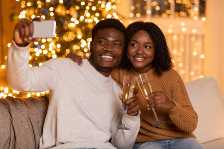 Millennial Couple Cheers With Champagne and Takes Selfie During Holiday Celebrationの写真素材
