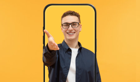 Young Man Greeting With a Smile in a Vibrant Yellow Background Settingの写真素材