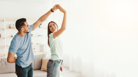 Couple Enjoying a Joyful Moment Dancing Together in a Bright Living Roomの写真素材