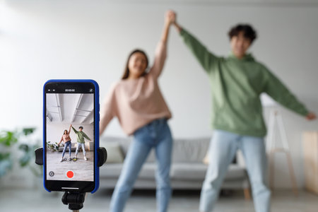Cheery Couple Enjoying Dance Video Shoot at Home for Social Network Contentの写真素材