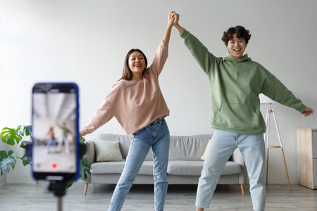 Happy Young Couple Creates Fun Dance Video at Home for Their Vlog Audienceの写真素材