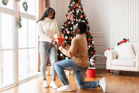 Happy Family Enjoying Christmas With Gifts Around the Decorated Tree in Living Roomの写真素材