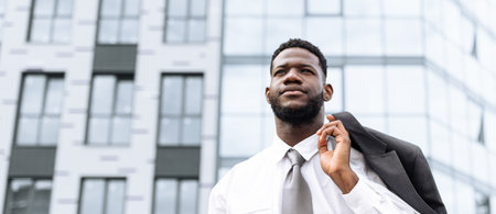 Businessman in a Suit Walking Confidently Outside a Modern Office Building During the Daytimeの写真素材