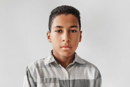 Serious African American Preteen Boy Poses for School Portrait Against Gray Backgroundの写真素材