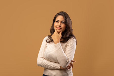 Portrait of pensive arab lady touching chin and thinking about something, considering interesting offerの写真素材