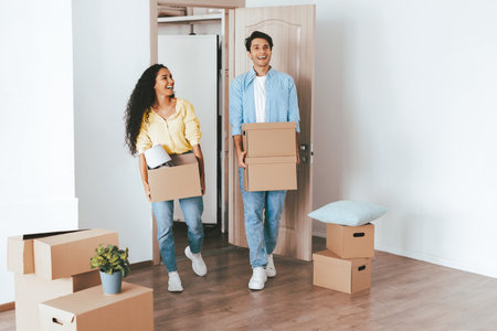 Young Couple Moving Into Their New Home With Boxes and Smiles on a Sunny Dayの写真素材