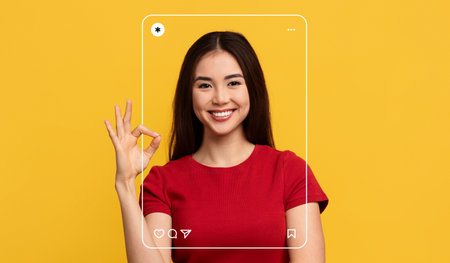 Joyful Woman Making an Okay Sign Against a Bright Yellow Background