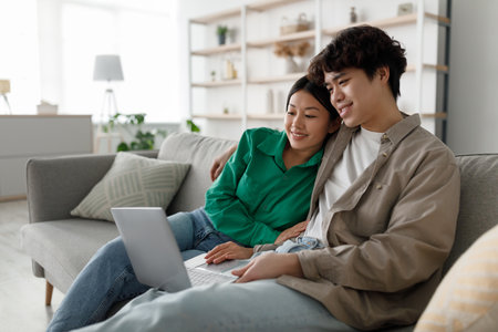 Married Couple Enjoys Quiet Weekend Together While Watching Movie on Laptop at Homeの写真素材
