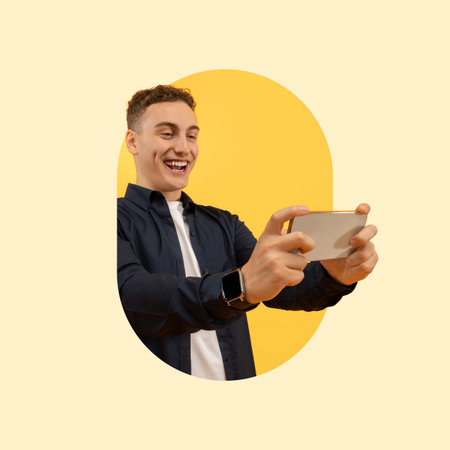 Young Man Enjoying Gaming on His Smartphone in a Bright Yellow Background Collageの写真素材