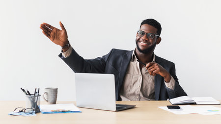 Young Entrepreneur Gives Presentation Using Laptop at Desk in Professional Setting