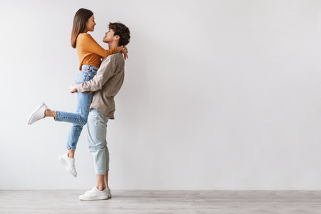 Romantic Young Couple Sharing a Warm Embrace in a Stylish Studio Settingの写真素材