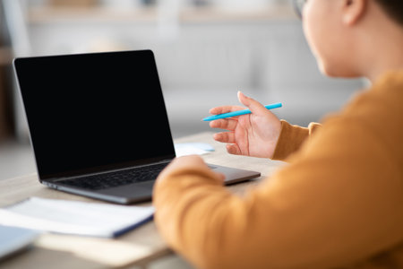 Chubby Boy With Glasses Engaged in Homework and Video Call at a Table
