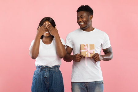 Happy Couple Shares Surprise Gift Moment in a Cheerful Settingの写真素材