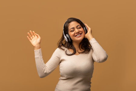 Move your body. Happy woman listening to music in wireless headphones with closed eyes, enjoying new playlistの写真素材