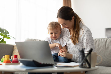 Loving Mother Spends Quality Time With Her Joyful Son While Working From Homeの写真素材