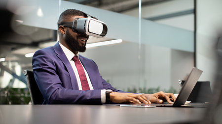 Smiling african american manager using VR glasses and laptopの写真素材