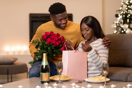 Husband Surprises Wife With Flowers and Gift During a Romantic Dinner at Homeの写真素材