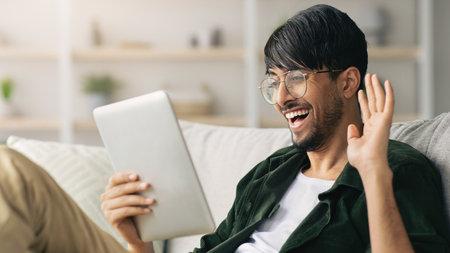Young Man Enjoying Video Call While Sitting on Couch at Home in Casual Setting