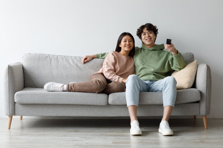 Relaxing Couple Enjoys Cozy Movie Time at Home on a Comfortable Couch Togetherの写真素材