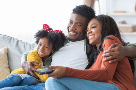 Family Enjoying a Cozy Movie Night Together on a Couch With Smiles and Laughter in a Comfortable...