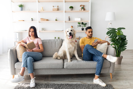 Couple Relaxing on a Couch With Golden Retriever in Modern Living Room During Daytimeの写真素材