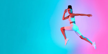 Dynamic Woman Performing a Jump in Vibrant and Colorful Workout Attireの写真素材