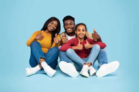 Family of Three Sharing Joy and Approval With Thumbs up in Blue Studio Background