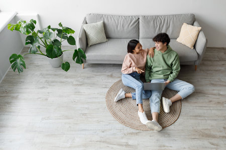 Happy Young Couple Enjoying Time Together at Home With Laptopの写真素材