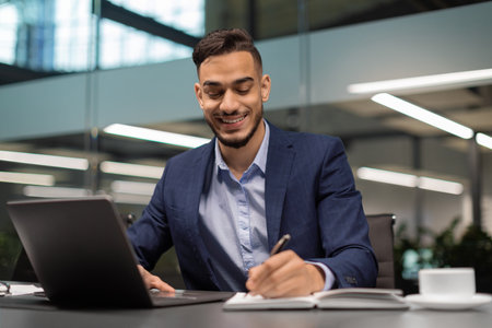 Successful Middle Eastern Businessman Works at Modern Office With Laptop and Notes