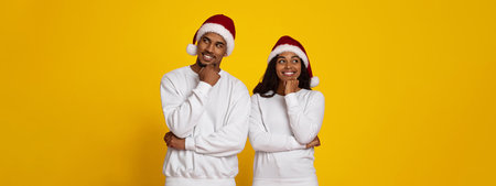 Cheerful Couple in Christmas Hats Posing Against Bright Yellow Background