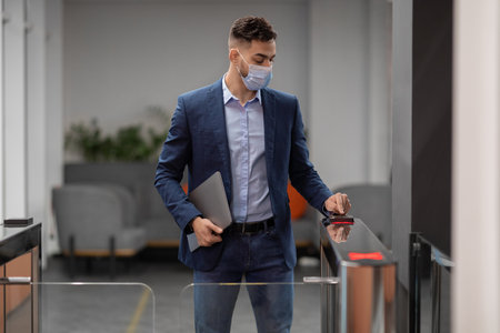 Employee in Face Mask Entering Security Code to Access Office Buildingの写真素材