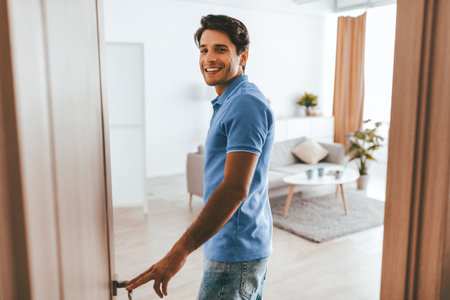 Young Man Entering a Modern Living Space With a Cheerful Smileの写真素材